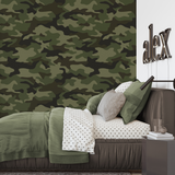 "Wall Blush's Abbott Wallpaper featured in a stylish bedroom, highlighting the bold camouflage pattern."