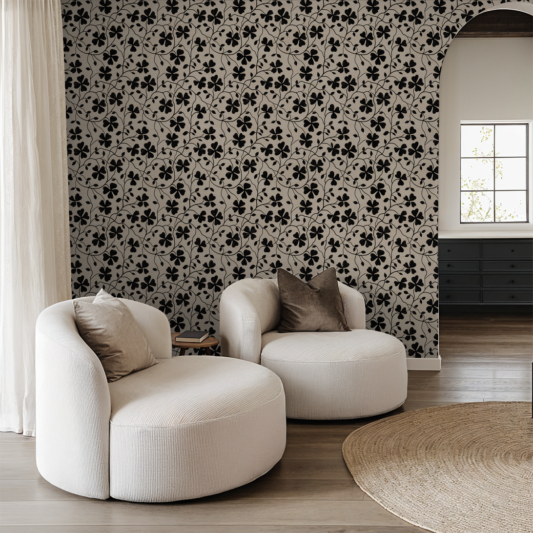 Black floral wallpaper in modern living room with white chairs and archway.