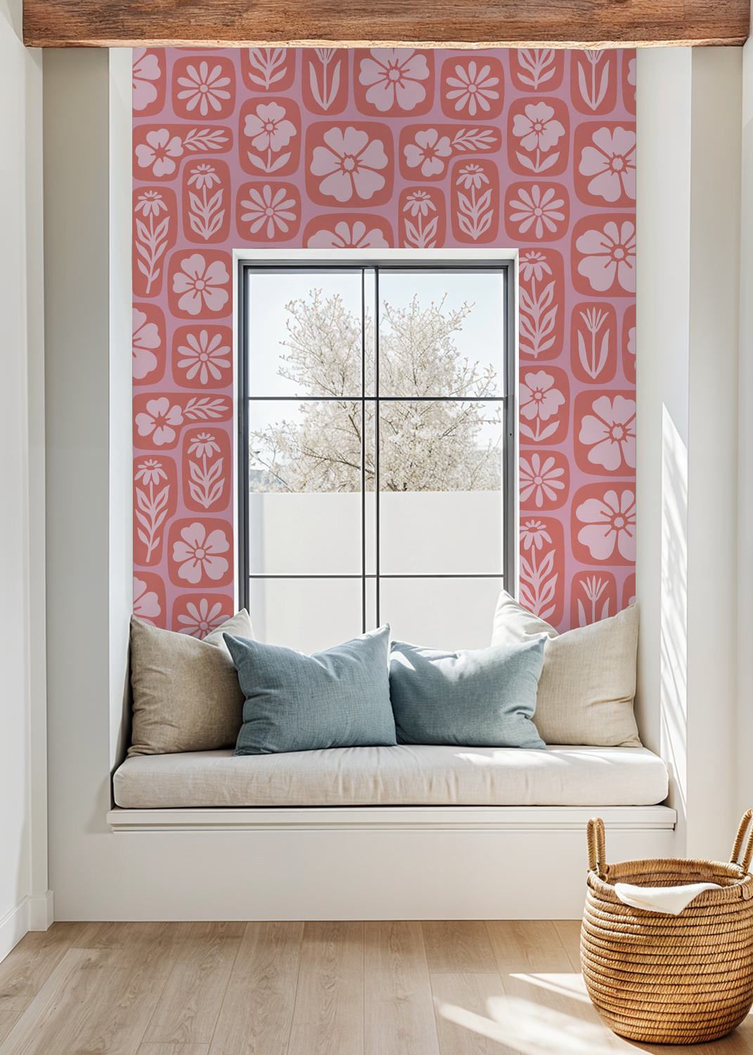 Coral floral wallpaper in cozy nook with cushions and window view.