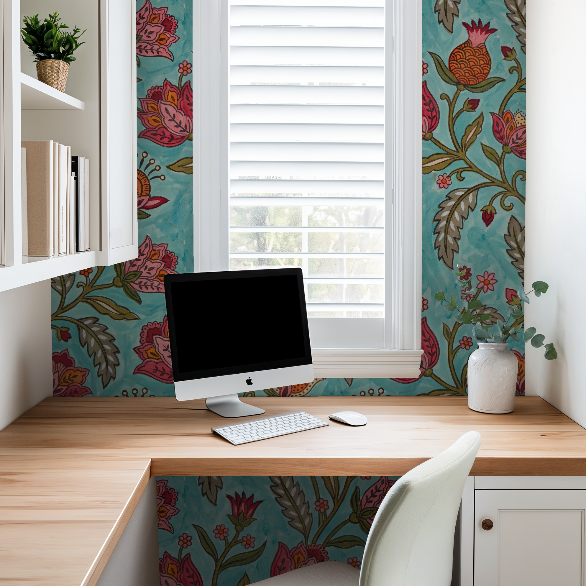 Floral wallpaper with red and orange motifs on teal in a home office setting.