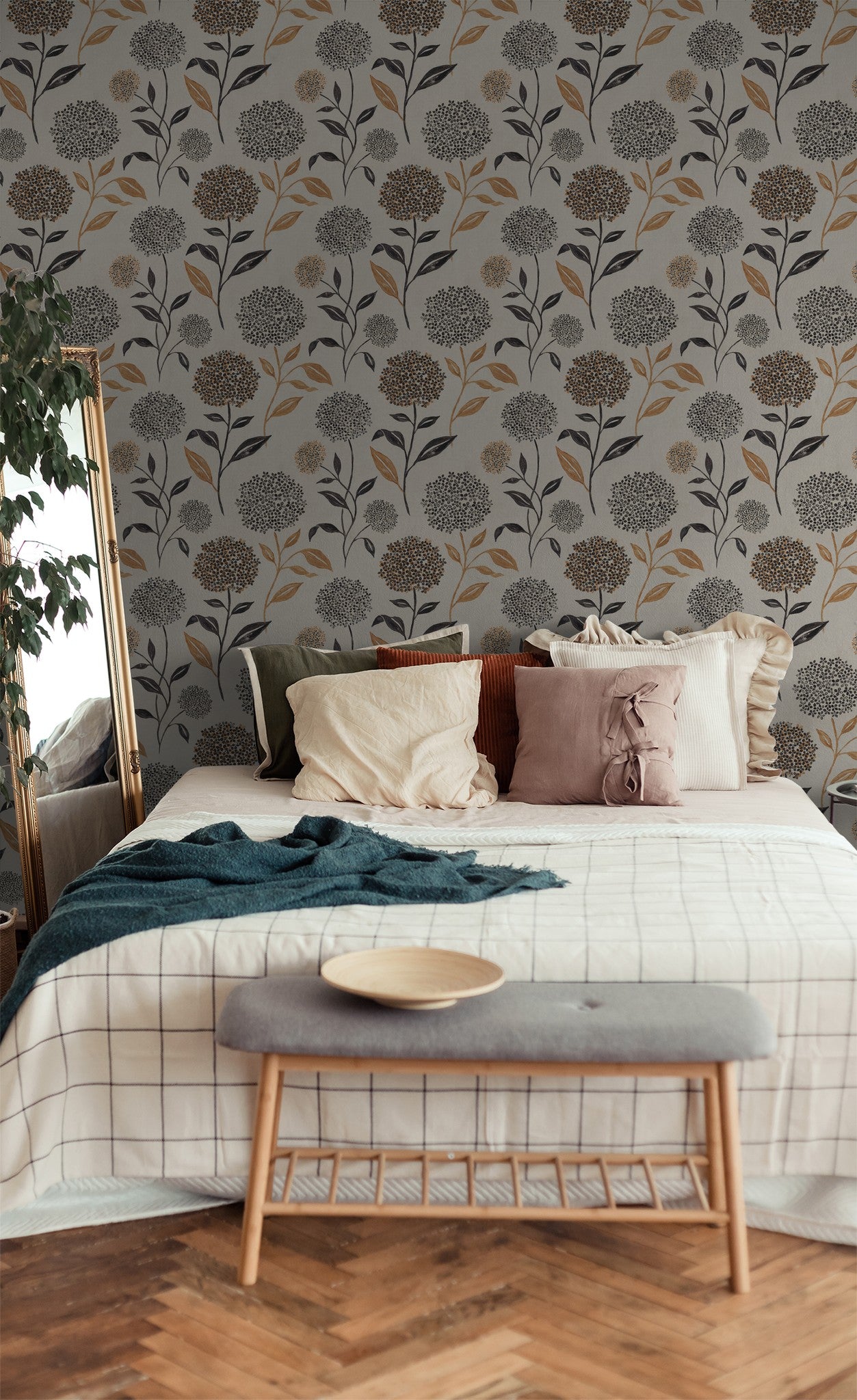 Floral wallpaper with terracotta and charcoal blooms in cozy bedroom setting.