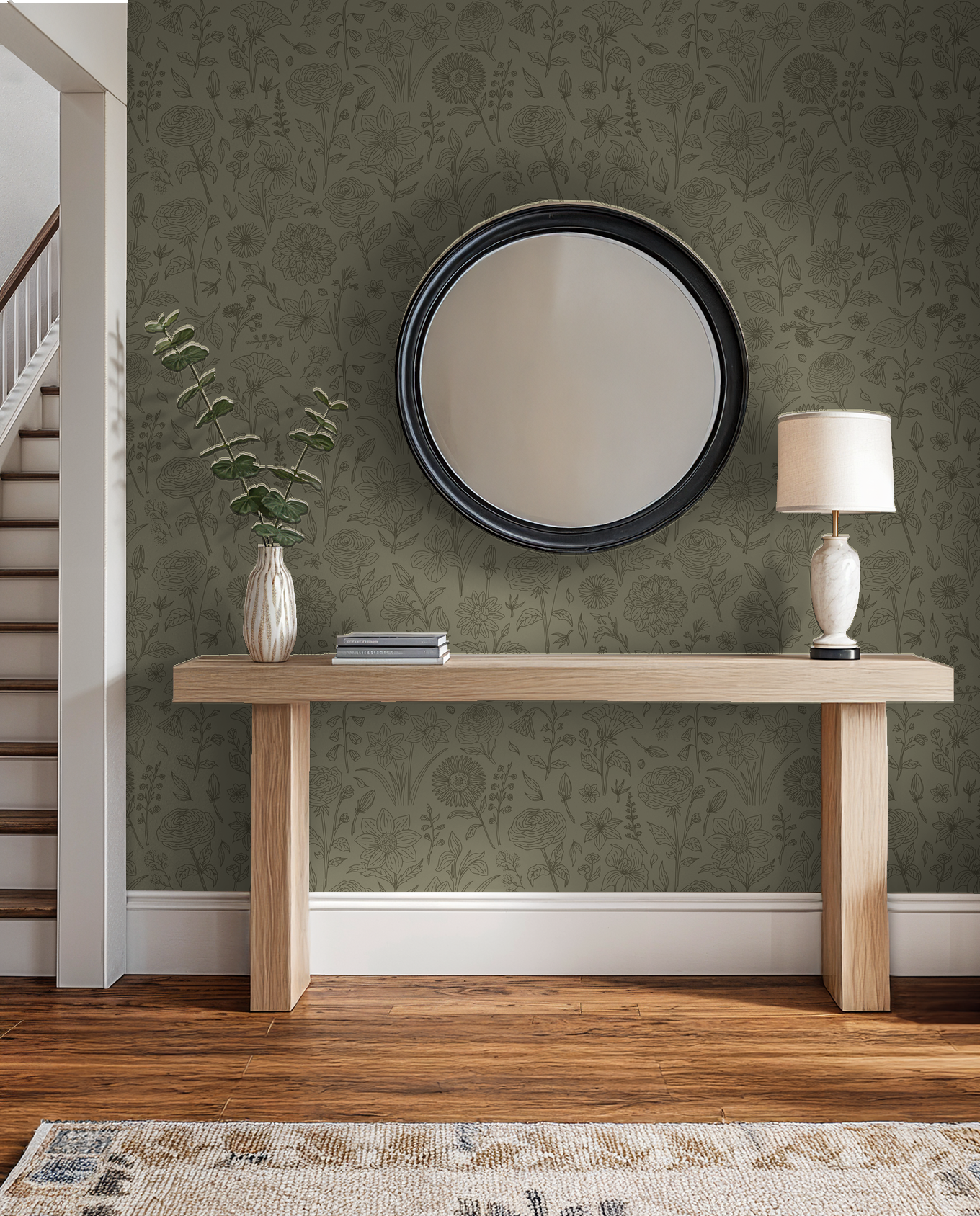Green floral wallpaper with line-drawn flowers in a hallway with a mirror and wooden console.