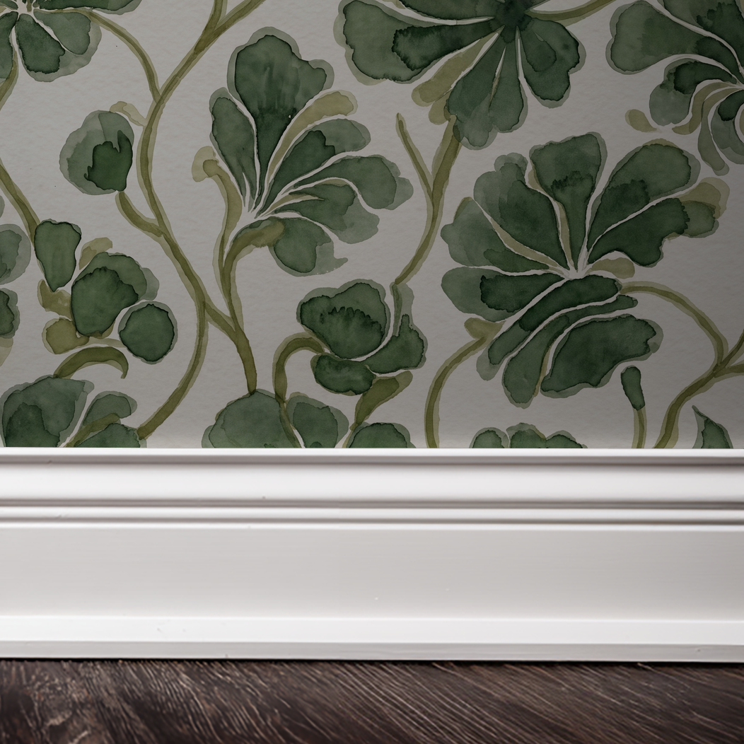 Green foliage watercolor wallpaper with white baseboard and dark wood floor.