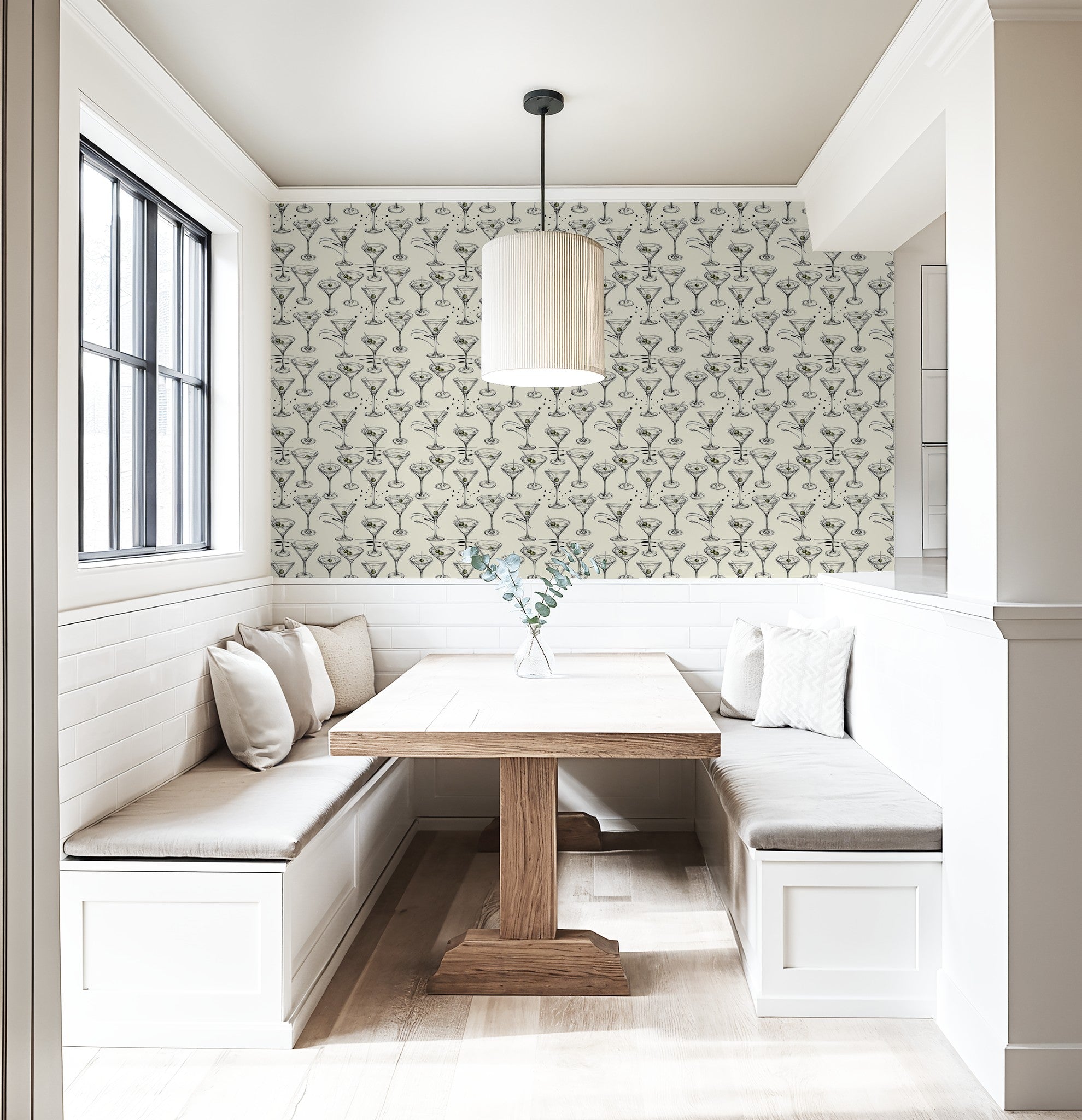 Martini glass wallpaper in cream dining nook with wood table and pendant light.