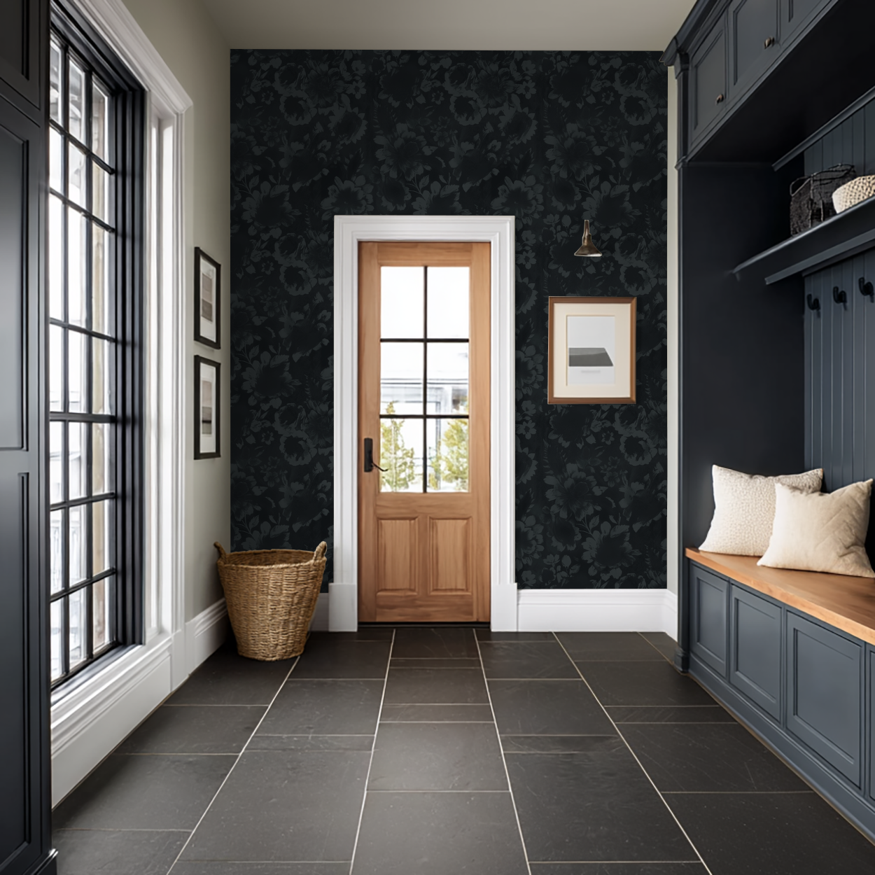 Navy floral wallpaper with shadowy blooms in elegant entryway with wooden door and bench.