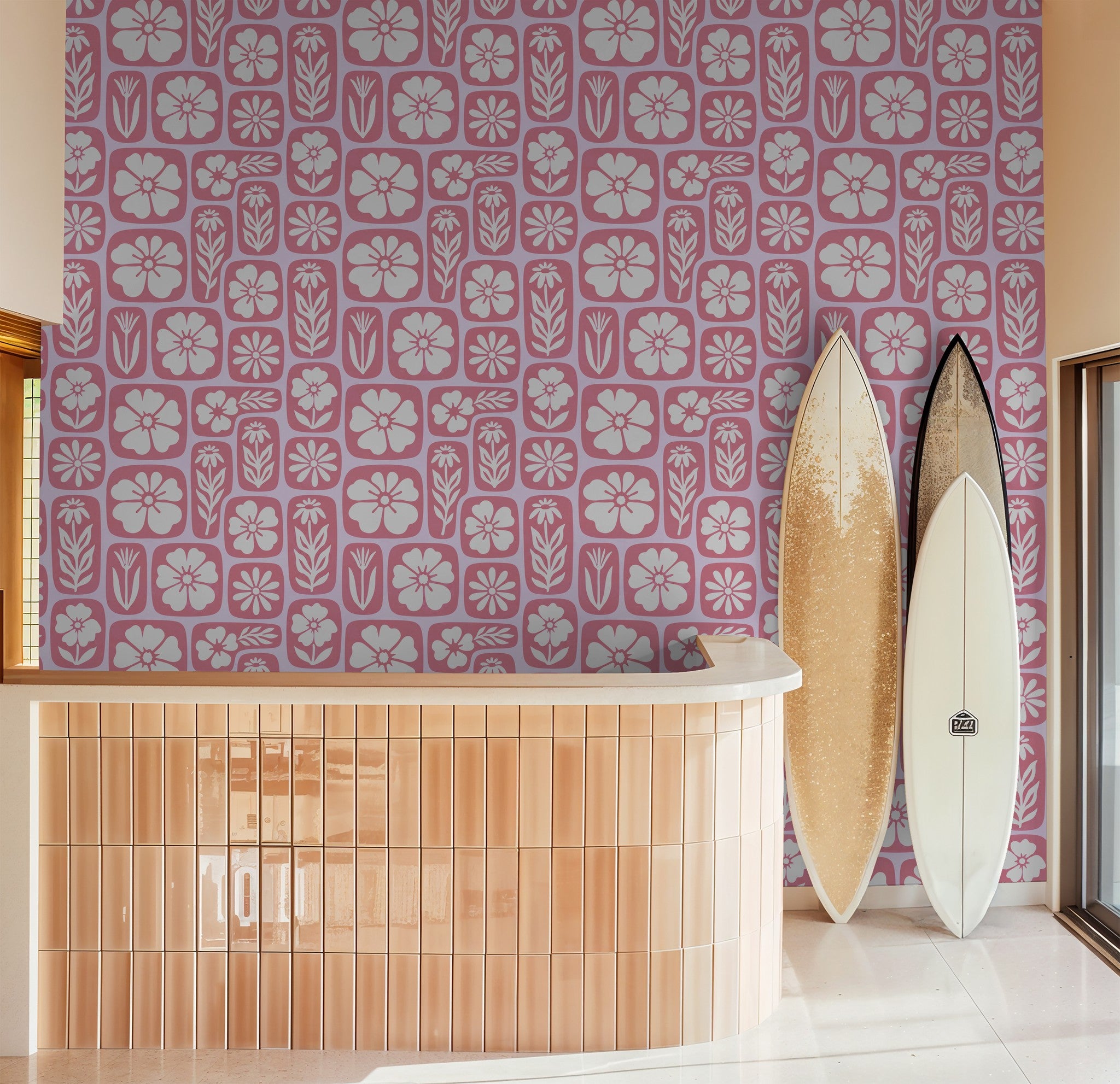 Retro floral pink and white wallpaper in room with surfboards and curved counter.