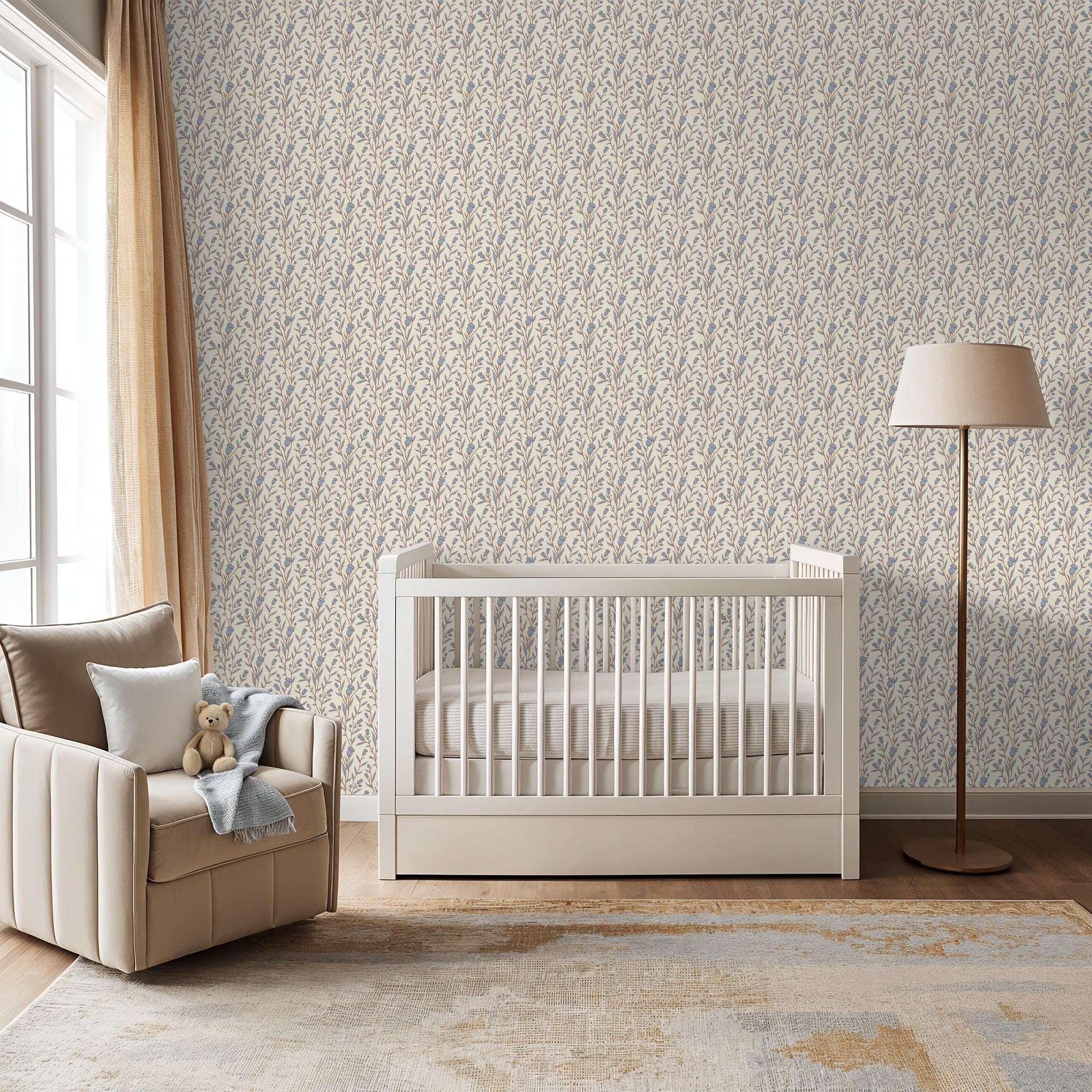 Thistle motif wallpaper in blue and brown in a cozy nursery with crib and armchair.