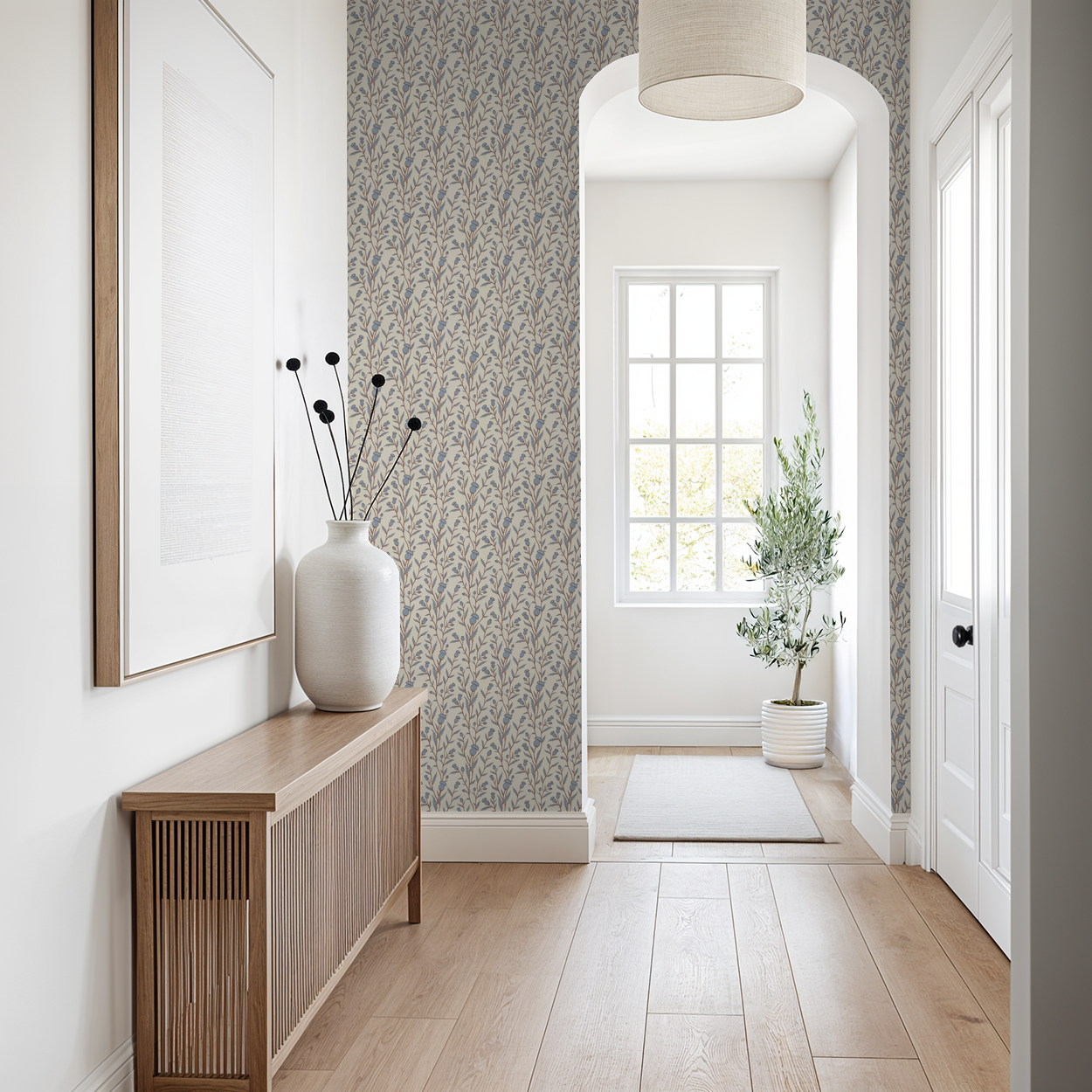 Thistle motif wallpaper in blue and brown in a bright hallway with wooden furniture.