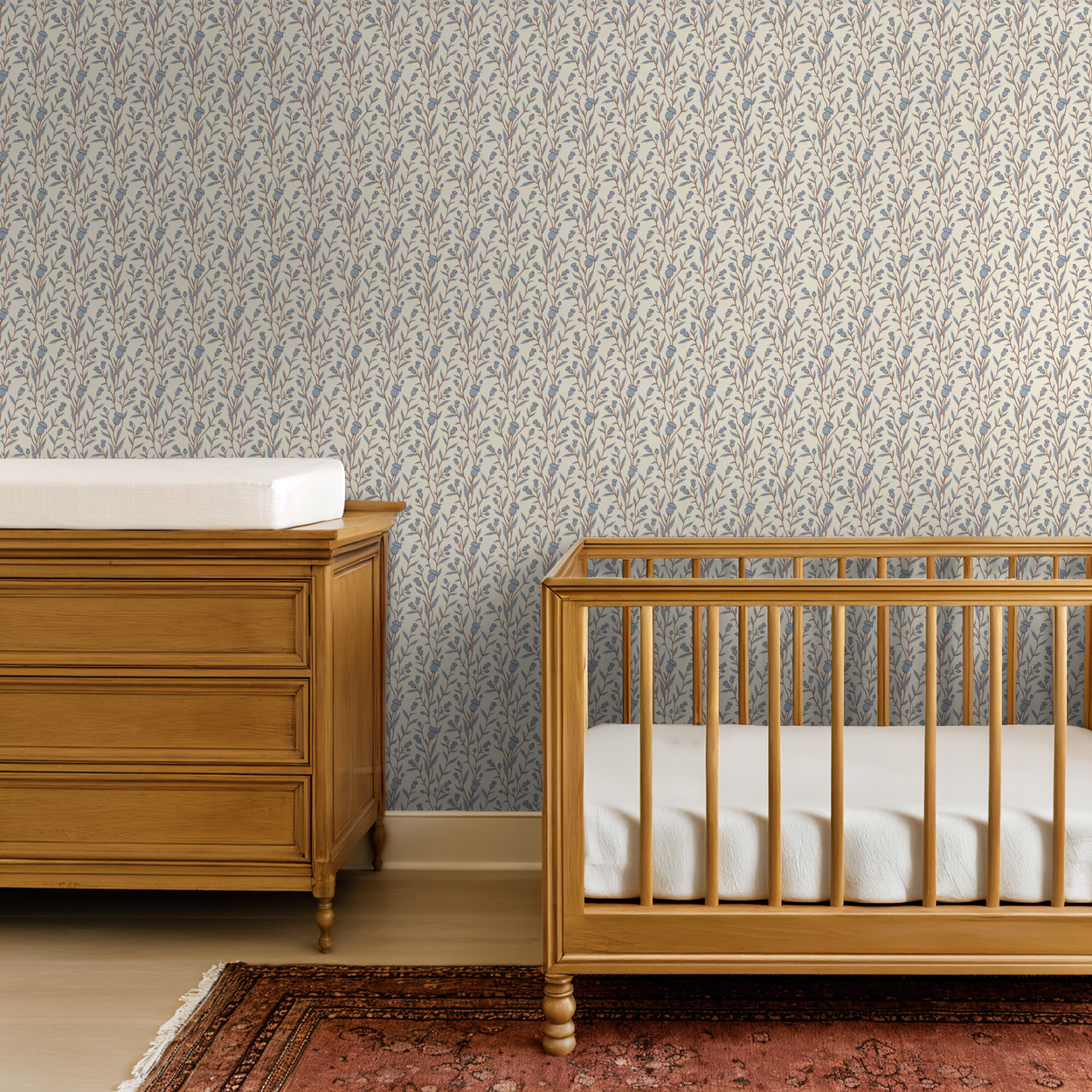 Thistle motif wallpaper in blue and brown in a nursery with wooden crib and dresser.