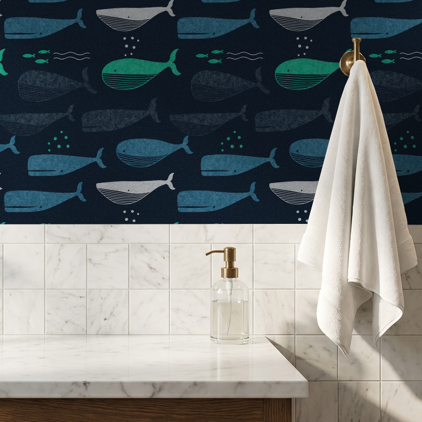 Whale pattern wallpaper in navy, teal, and white above a marble countertop with towel.