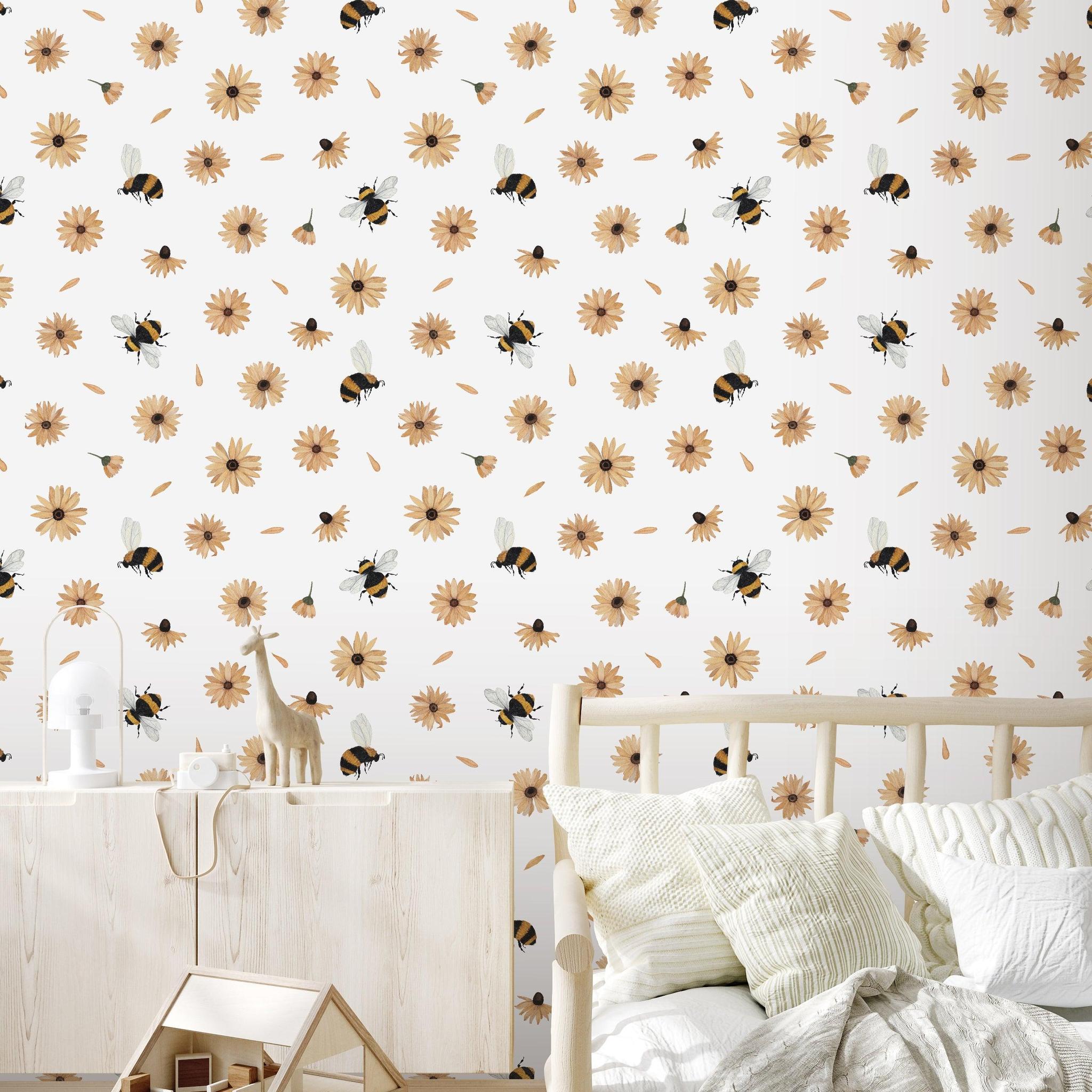 Alt: Wall Blush's Bumble (White) Wallpaper featuring bees and flowers adorns a cozy, children's bedroom, highlighting the wall decor.