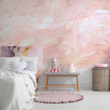 "The Nora Mural Wallpaper by Wall Blush in a cozy bedroom, highlighting soft pink brush strokes."