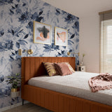 "Wall Blush's Wild Blues Wallpaper showcasing floral design in a stylish bedroom setting, accented with modern decor."