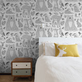 Alt: "Wall Blush Woodland Wallpaper in cozy bedroom, with animal illustrations, focusing on the wall décor."