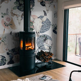 "Wall Blush's Lawless Rose Wallpaper featured in a cozy living room with a wood stove focal point."