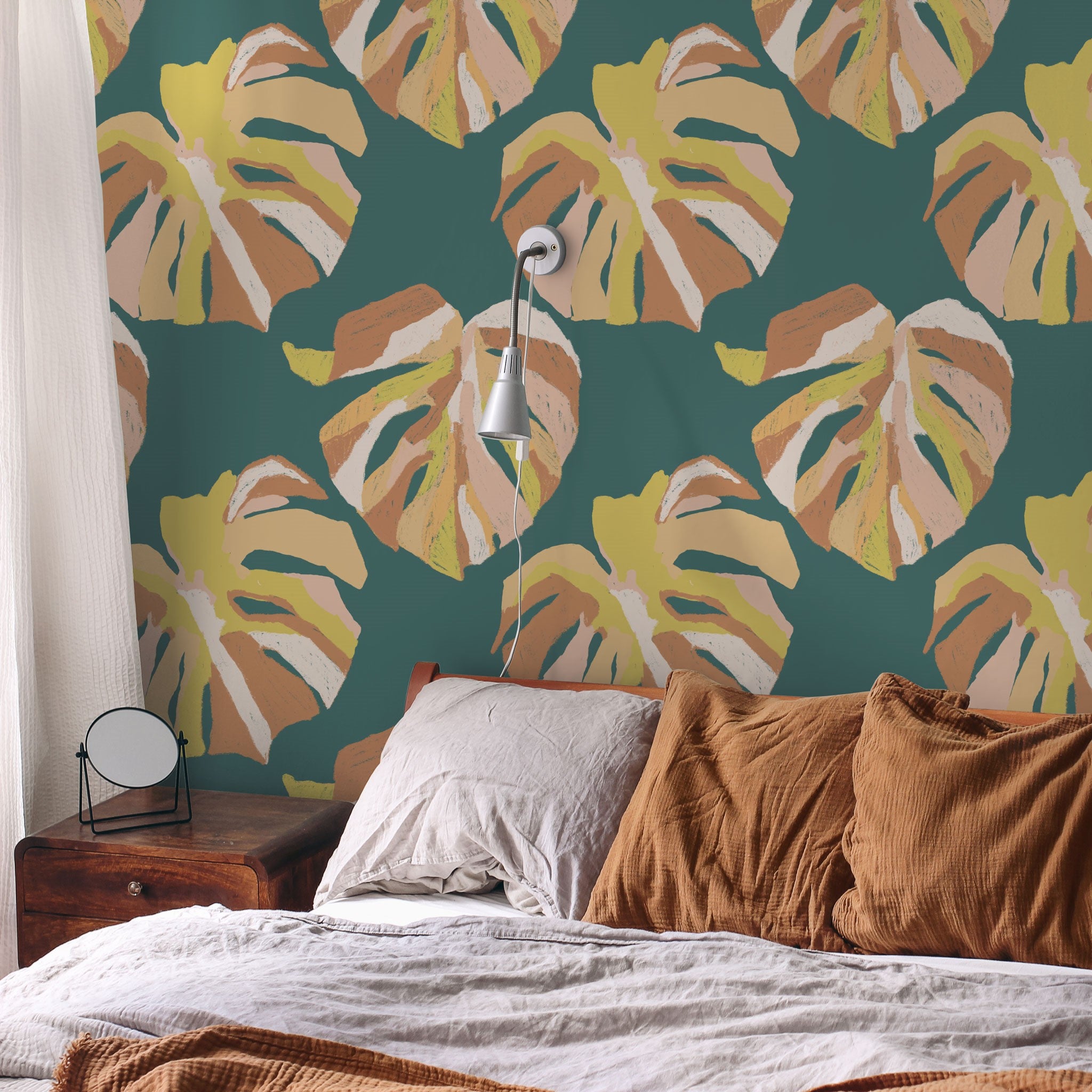 "Wall Blush Monstera Wallpaper adds a tropical vibe to the bedroom, with lush green and yellow leaf patterns."