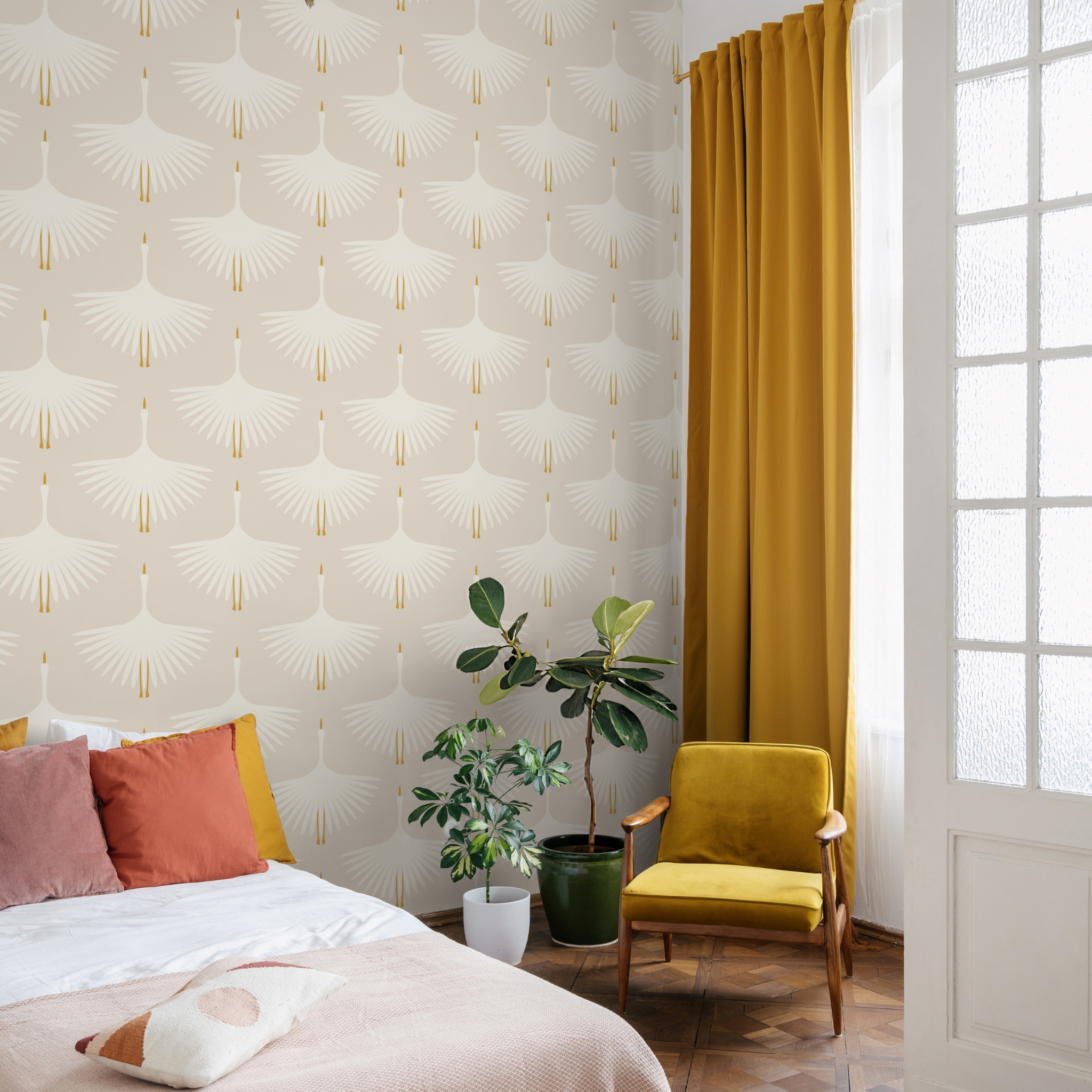 "Wall Blush Alba Cream Wallpaper in a cozy bedroom with yellow accents and green plants."