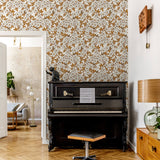 "Wall Blush Antoinette Wallpaper in elegant living room with piano, focusing on the floral patterned design."