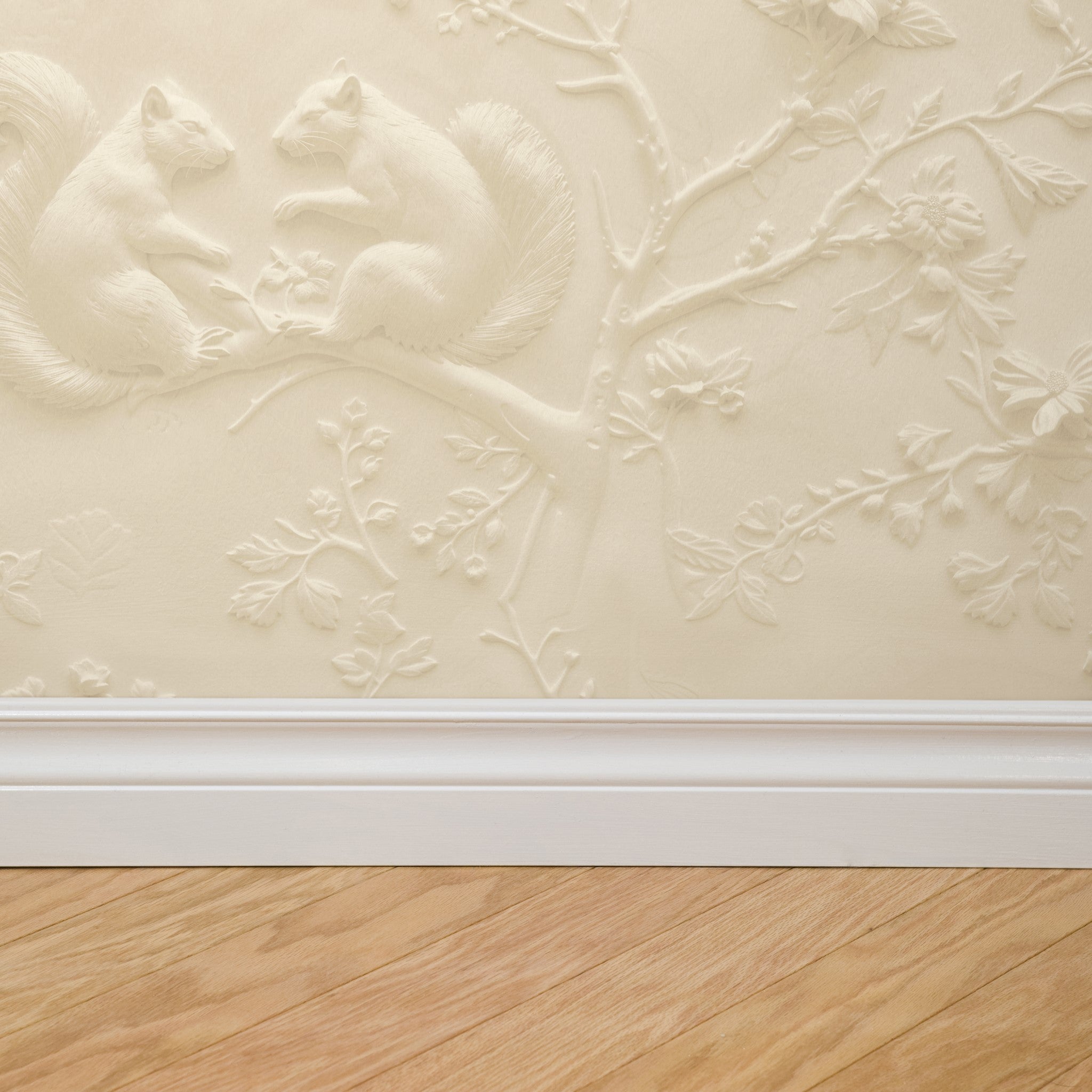 Alt: "Wall Blush Ivory Wallpaper with embossed squirrel design in a living room, focusing on wall texture and elegance."