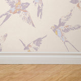 "Wall Blush's The Cheery Wallpaper with bird motif installed in a room with wooden flooring, showcasing elegant design."