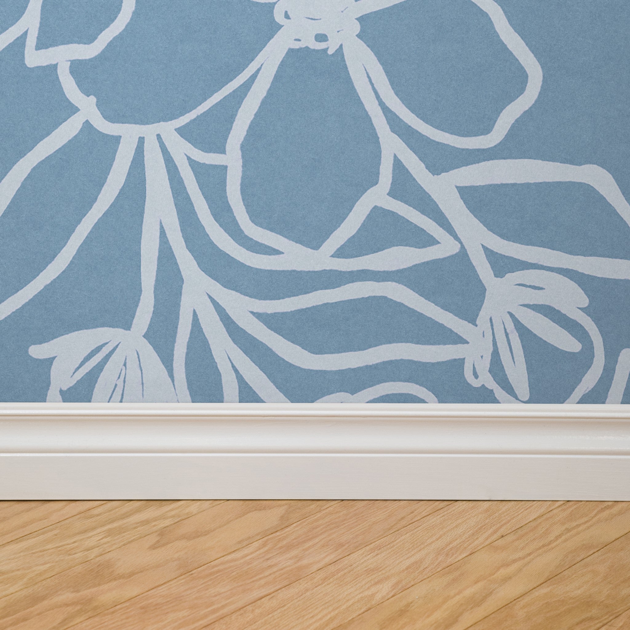 "Wall Blush brand Paige (Blue) Wallpaper featured in a stylish home interior with wood flooring."