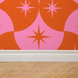 "Wall Blush's Margot Wallpaper featuring bold star patterns in a living room, highlighting vibrant decor."