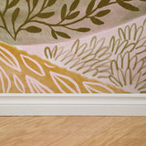 "Dorsia Wallpaper by Wall Blush with floral pattern, installed in a living room, showcasing warm tones."