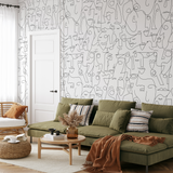 "Wall Blush's FACE IT Wallpaper enhancing modern living room decor with artistic face line drawings."