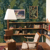 "Wall Blush Fraser Wallpaper showcasing its lush green pattern in a cozy reading room with vintage decor."