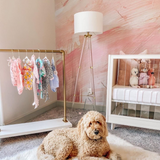 "The Nora Mural Wallpaper by Wall Blush in cozy nursery room, with stylish decor and plush dog on rug."