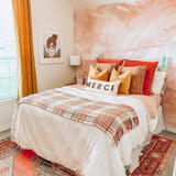 "The Nora Mural Wallpaper by Wall Blush enhancing a cozy bedroom ambiance with warm, abstract design."