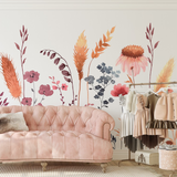 "Wall Blush's Untamed Wallpaper featuring floral design in a chic bedroom with a velvet sofa and stylish clothing rack."
