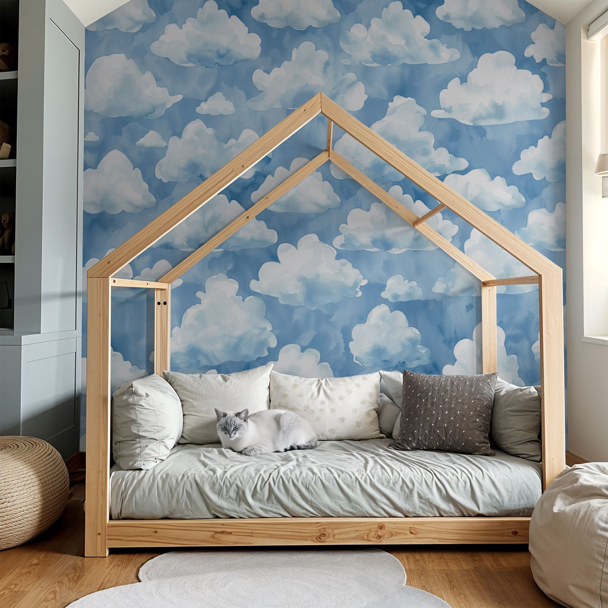 "Cozy children's room featuring 'Azure Dreamland Wallpaper' by Wall Blush with whimsical cloud design."