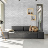 Bella Brick (White) Wallpaper by Wall Blush featured in a modern living room with natural light.
