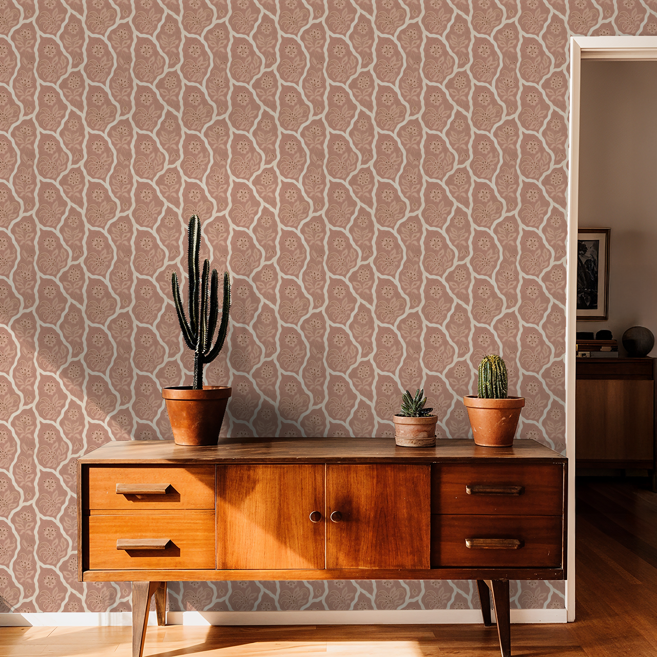 Bloomington floral wallpaper in blush tones with potted cacti on a wooden sideboard.