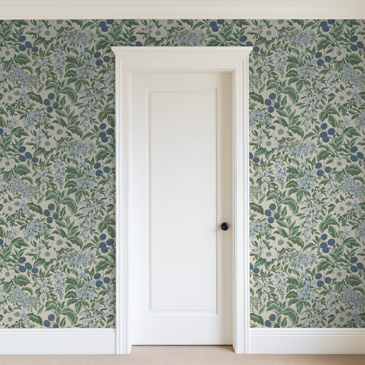 Bloomique Sage and Berry floral wallpaper with blue and green botanical pattern in a room with white door.
