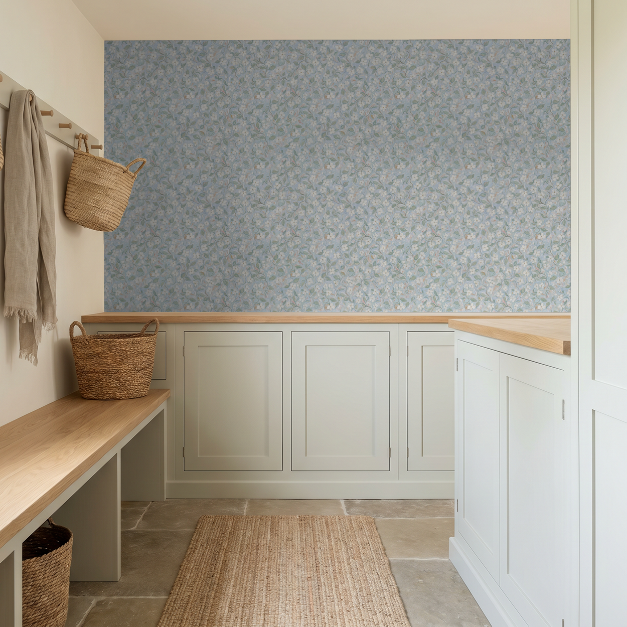 Blue floral wallpaper in a serene mudroom with wicker baskets and light wood accents.