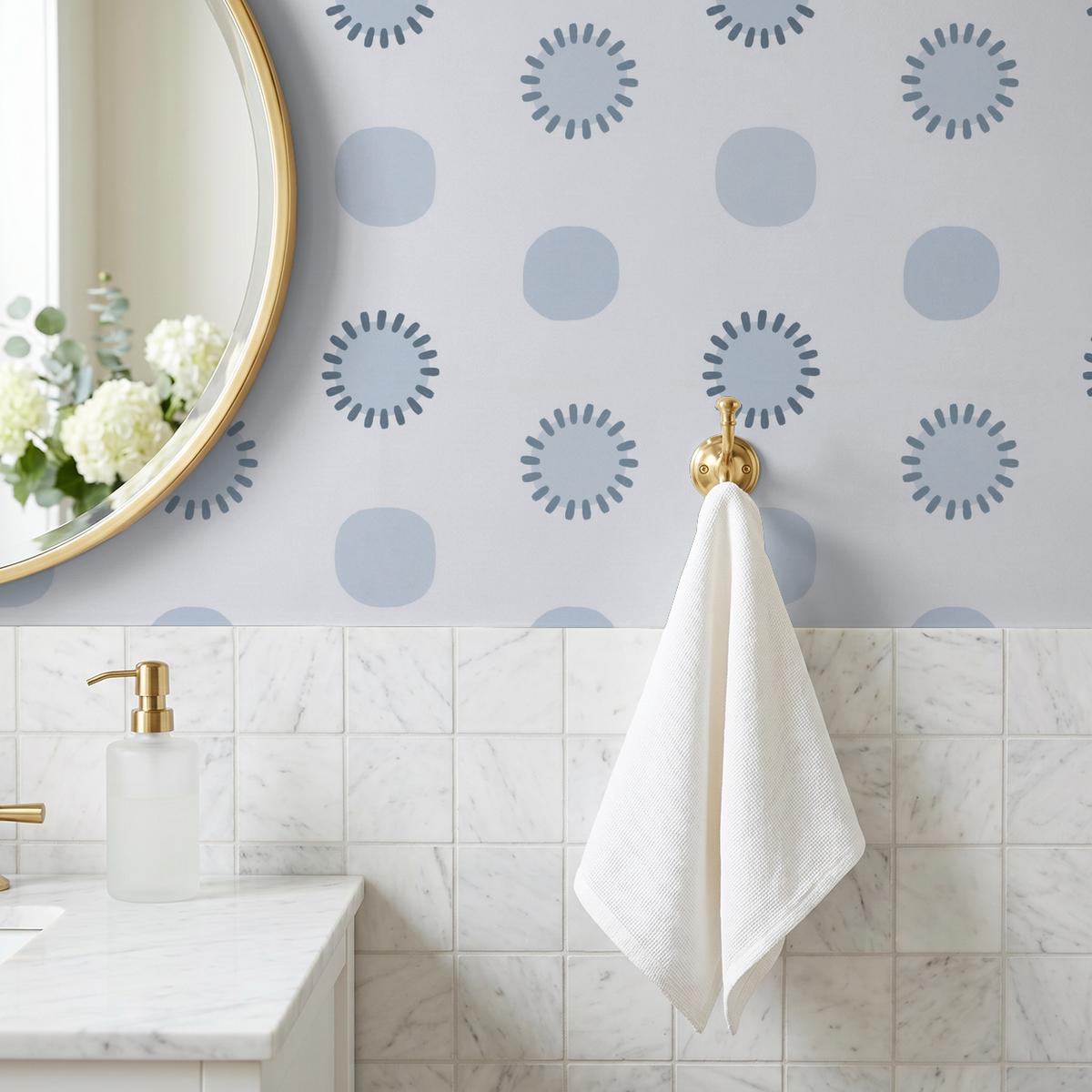 Blue geometric circle wallpaper in modern bathroom with gold mirror and white towel.