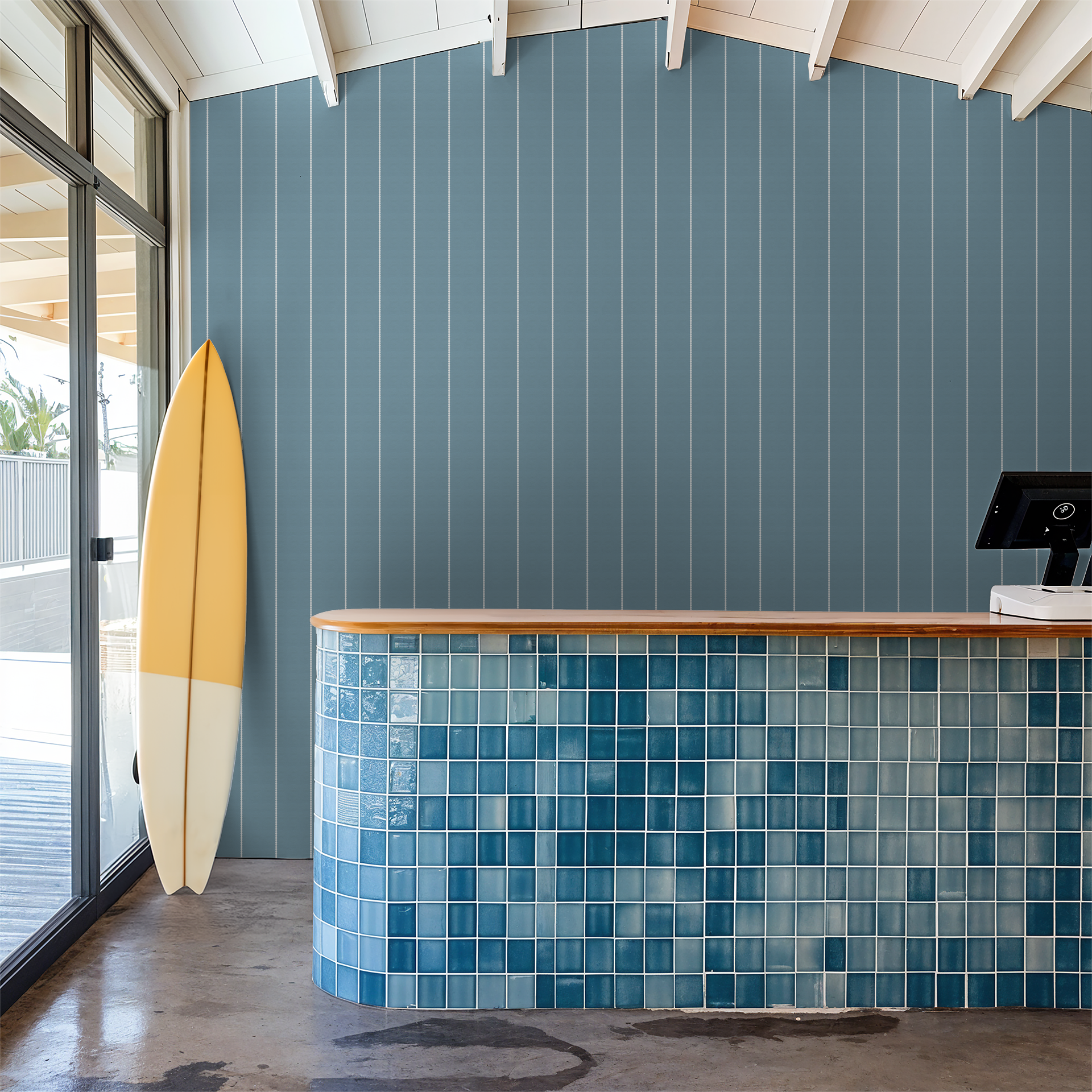 Blue pinstripe dot wallpaper in modern coastal room with surfboard and tiled counter.