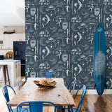 "Wall Blush Saltwater Surf (Blue) Wallpaper featured in stylish dining room decor with rustic table and surfboard."