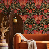 "Selene Wallpaper by Wall Blush in cozy living room with vibrant botanical design, statement orange sofa focus."