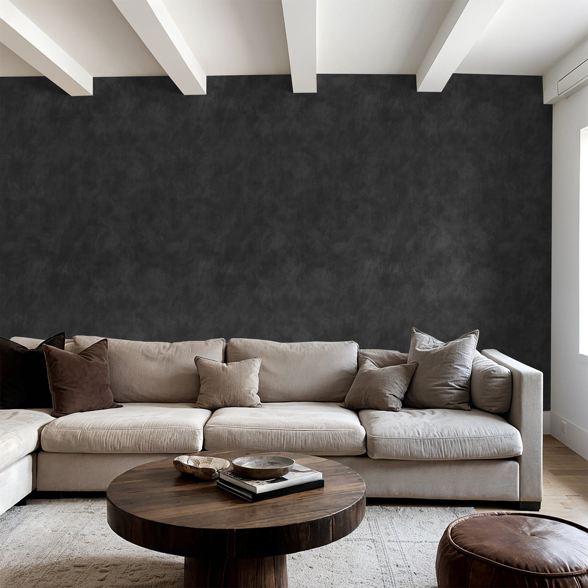 Charcoal limewash wallpaper in modern living room with beige sofa and wooden table.
