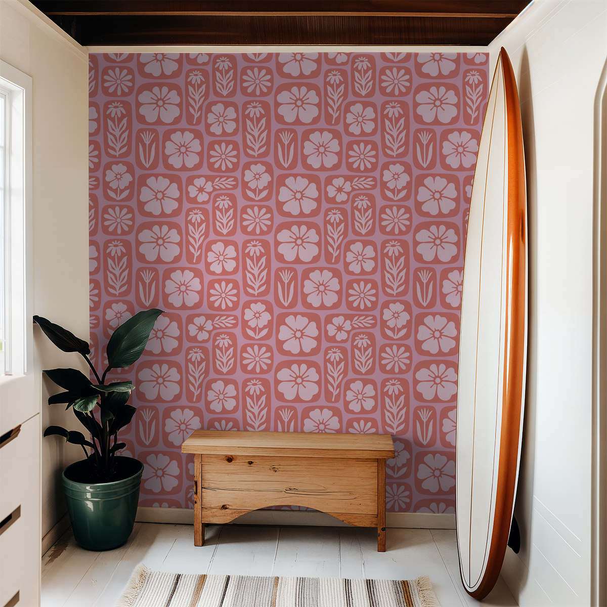 Coral floral wallpaper with pink motifs in a cozy room with bench and surfboard.