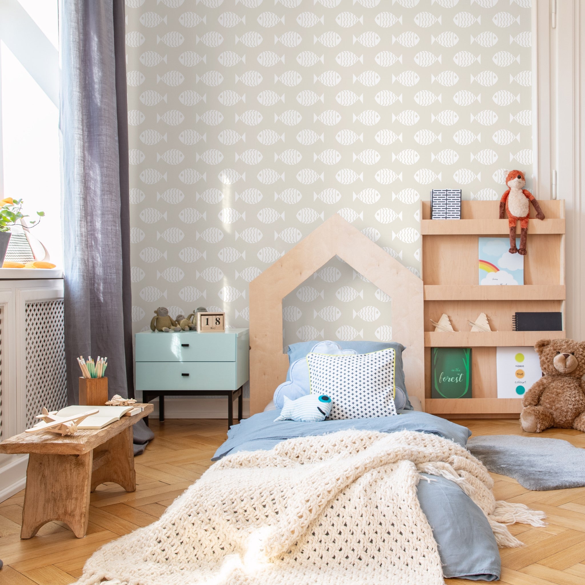 "Wall Blush's Keep Swimming Wallpaper in a cozy children's bedroom with stylish decor and wooden furniture."