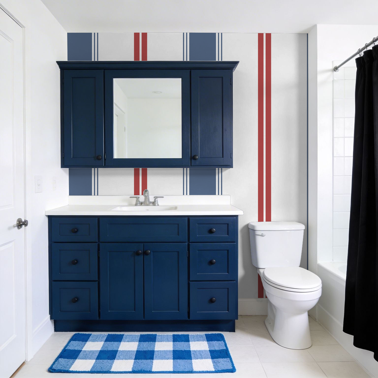 Bathroom with blue and red striped wallpaper and navy vanity.