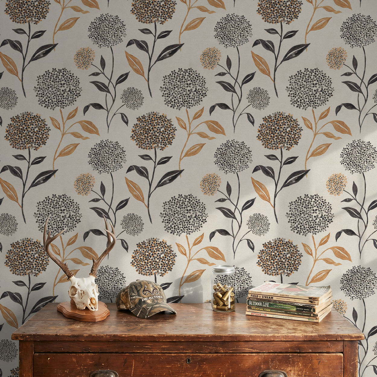 Floral wallpaper with terracotta and charcoal blooms on ivory backdrop in rustic setting.