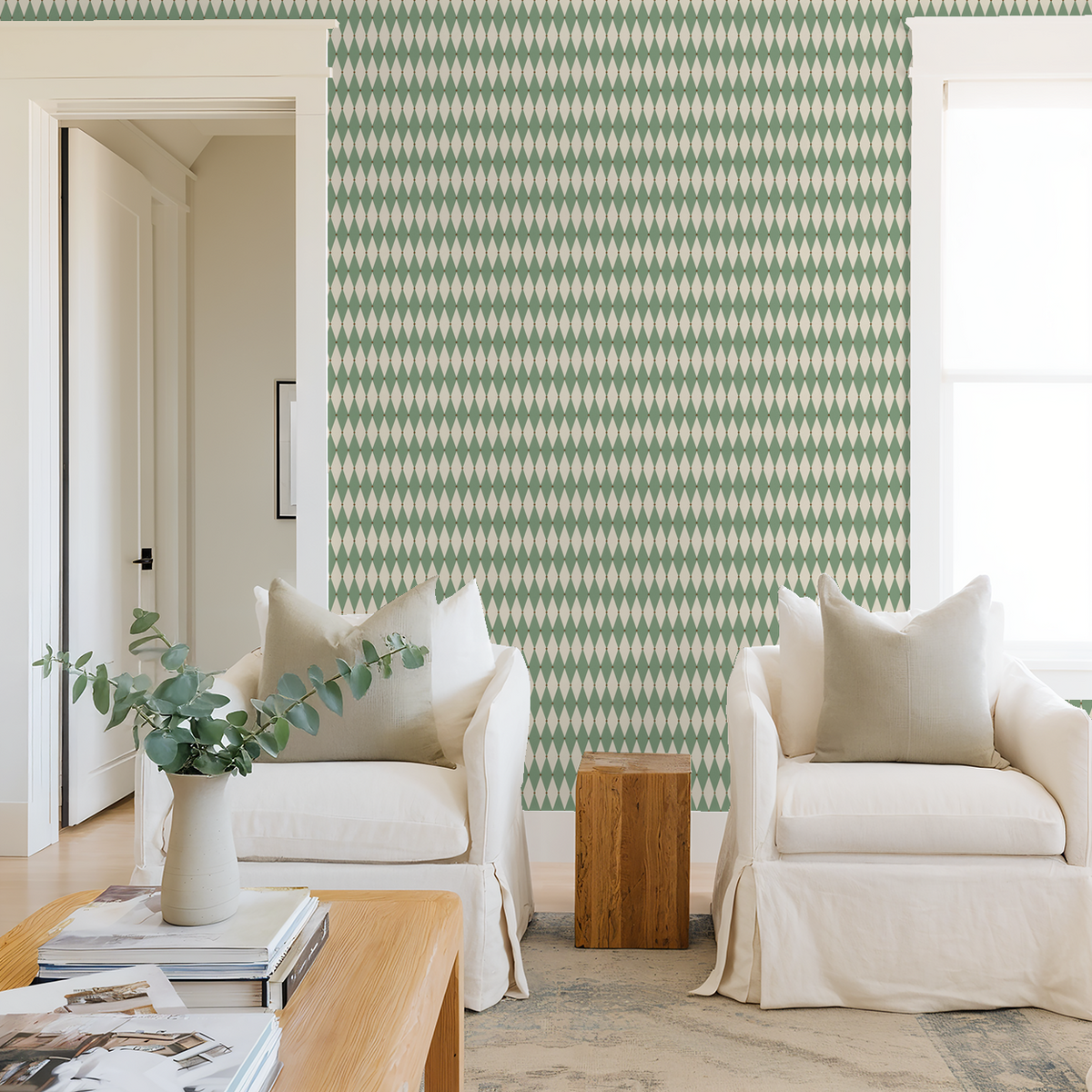 Green and cream diamond pattern wallpaper in a cozy living room with white armchairs.