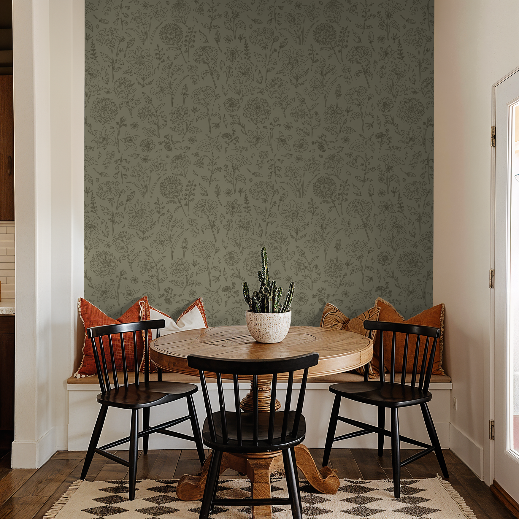 Green floral wallpaper with delicate line-drawn flowers in cozy dining room setting.