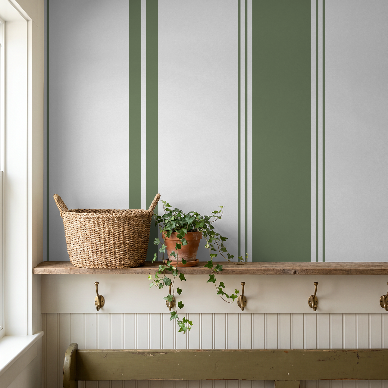 Green stripe wallpaper in cozy room with shelf, basket, and plant.