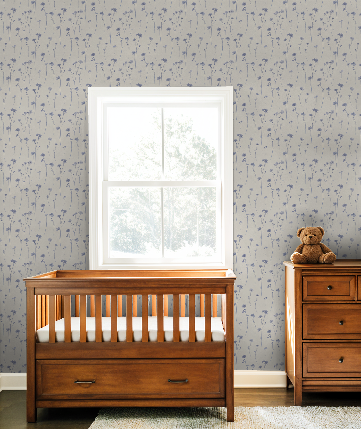 Lavender floral wallpaper in nursery with wooden crib and dresser